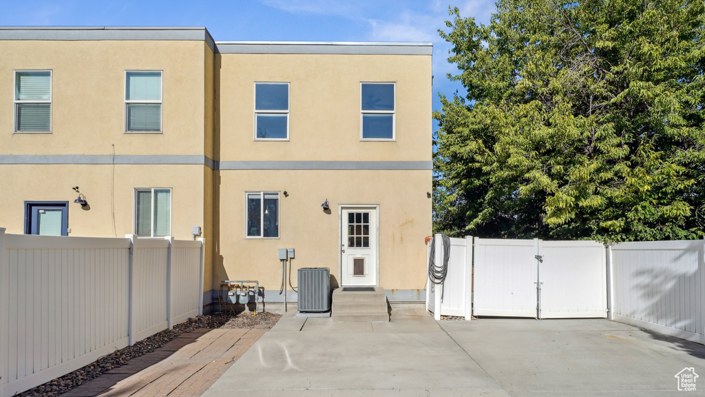 Back of house with a patio area and central air condition unit