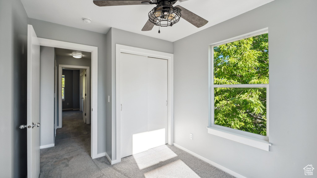 Unfurnished bedroom featuring a closet, ceiling fan, and light carpet