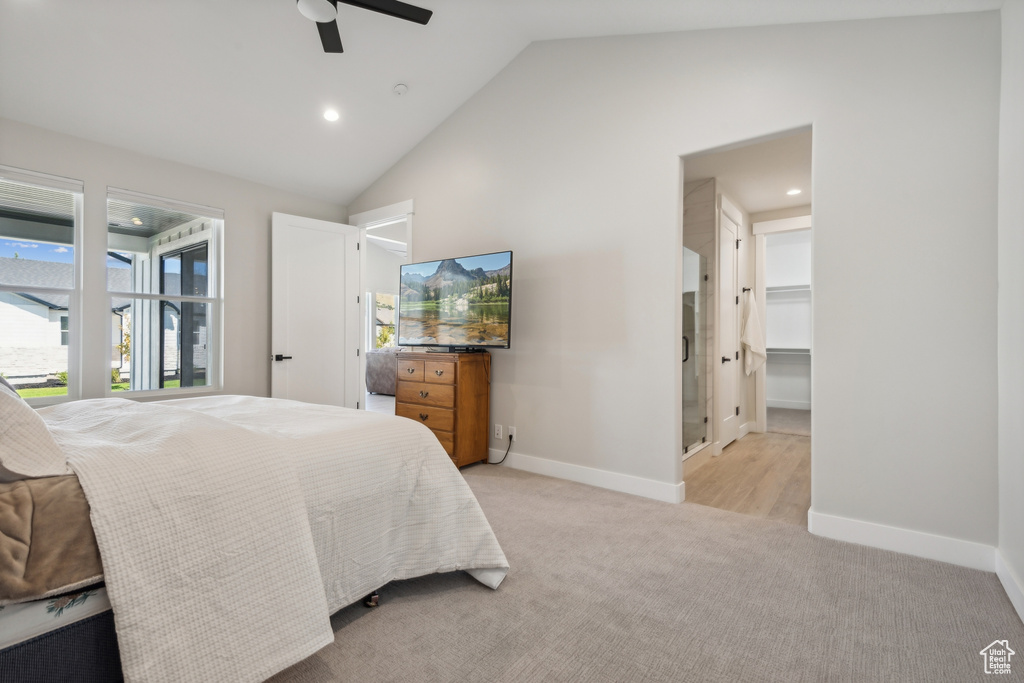 Bedroom with light colored carpet, lofted ceiling, a walk in closet, a closet, and ceiling fan