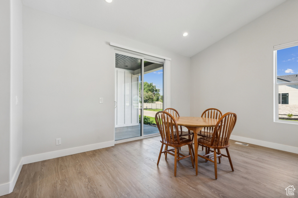 Dining space with lofted ceiling and light wood-type flooring