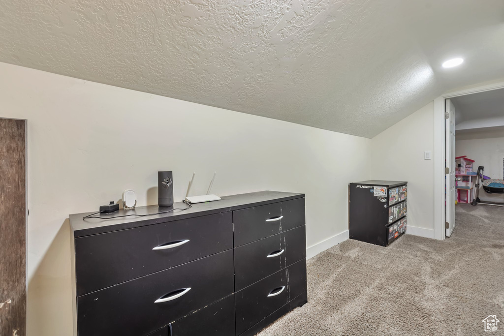 Interior space with light carpet and vaulted ceiling