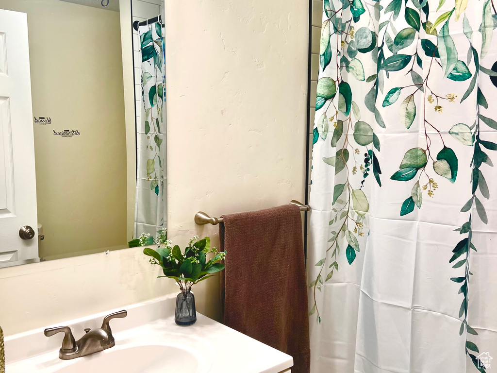Bathroom featuring shower / bath combo, a textured ceiling, and vanity