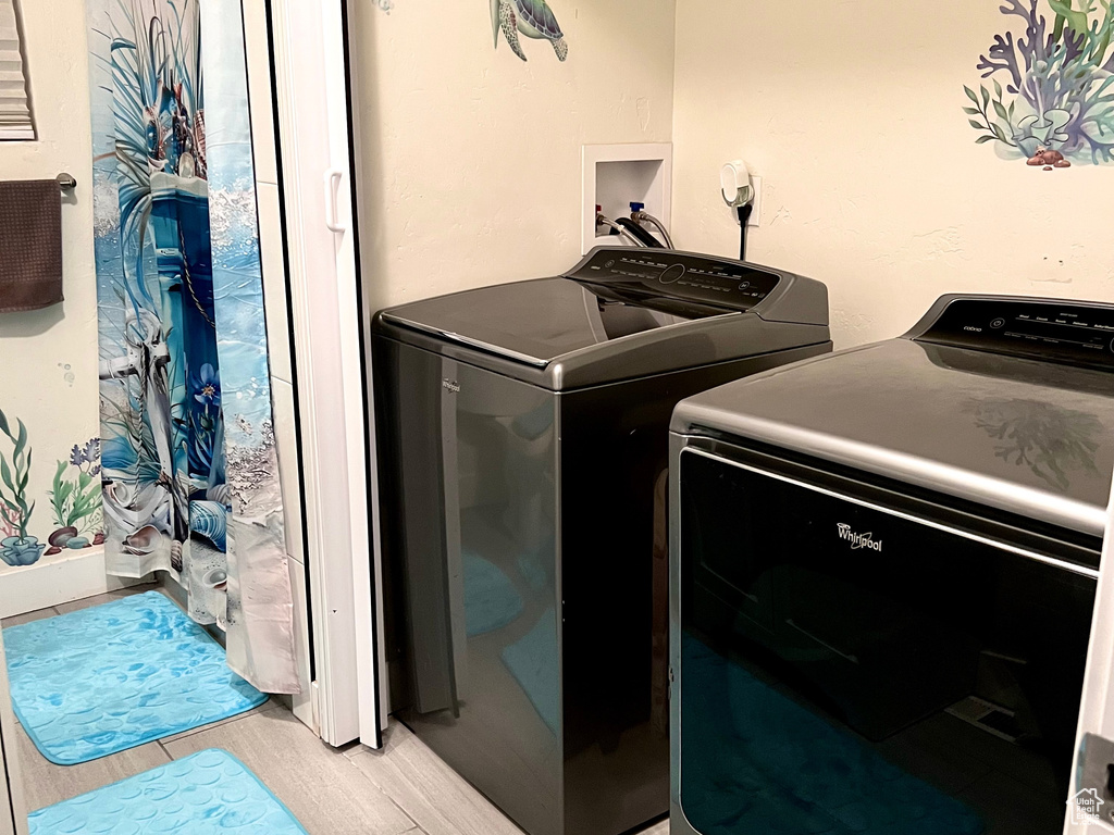 Washroom with separate washer and dryer, laundry area, and wood tiled floor
