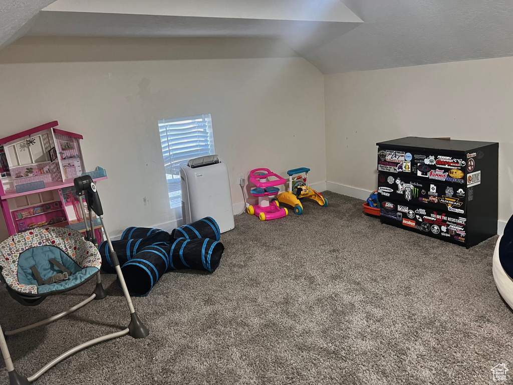 Recreation room featuring baseboards, vaulted ceiling, and carpet floors