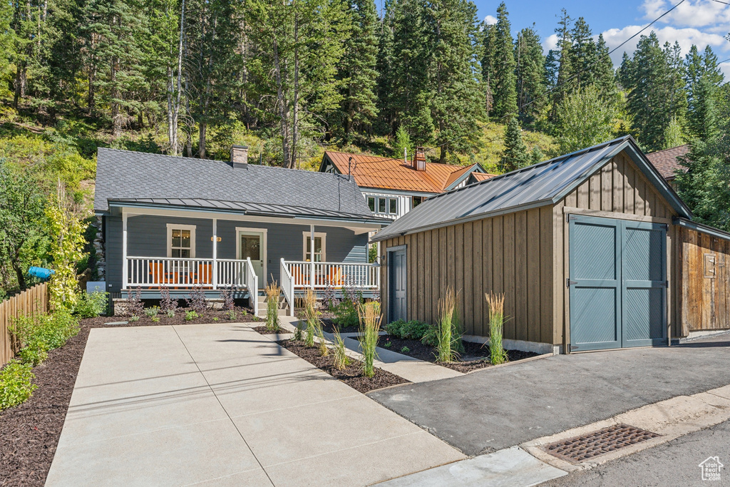 View of front of home featuring a storage shed and covered porch