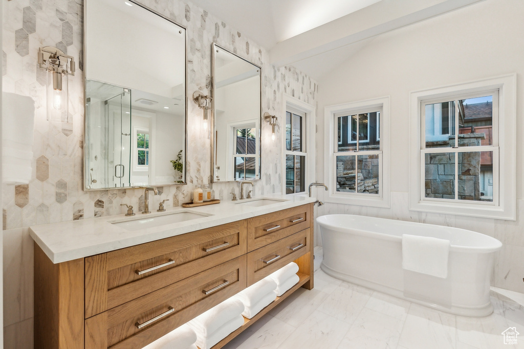 Bathroom with vaulted ceiling, vanity, and plus walk in shower