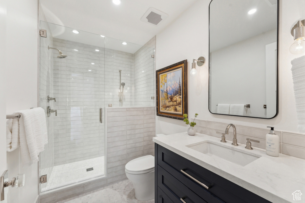 Bathroom with walk in shower, vanity, and toilet