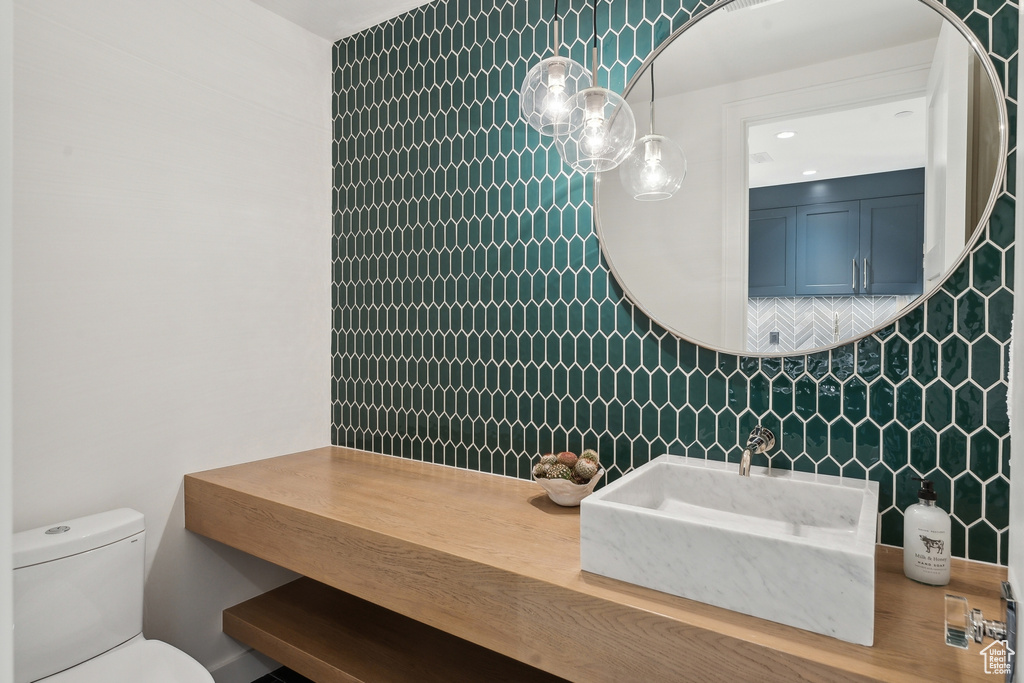 Bathroom with vanity, tile walls, and toilet