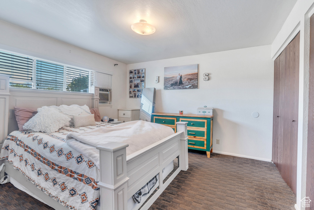 Bedroom with cooling unit, a closet, and dark hardwood / wood-style flooring