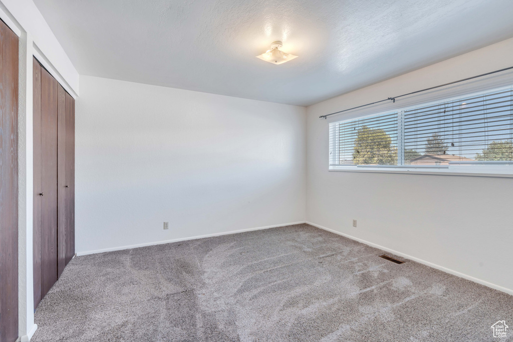 Unfurnished bedroom featuring a closet and carpet floors