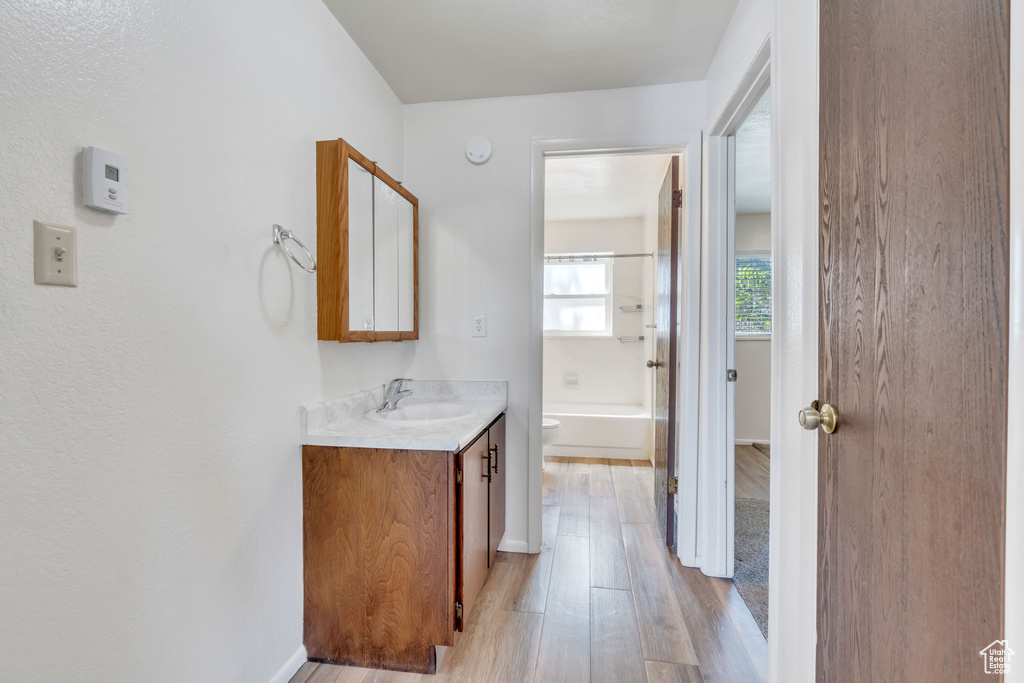 Bathroom featuring hardwood / wood-style floors, toilet, and vanity