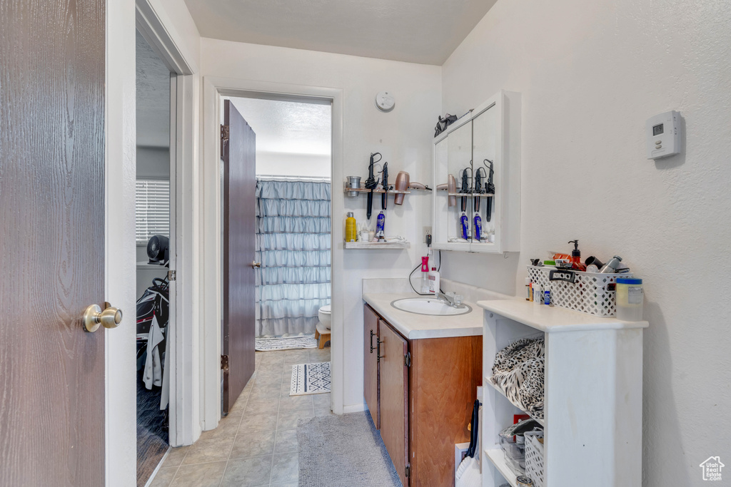 Bathroom featuring vanity, toilet, and tile patterned floors