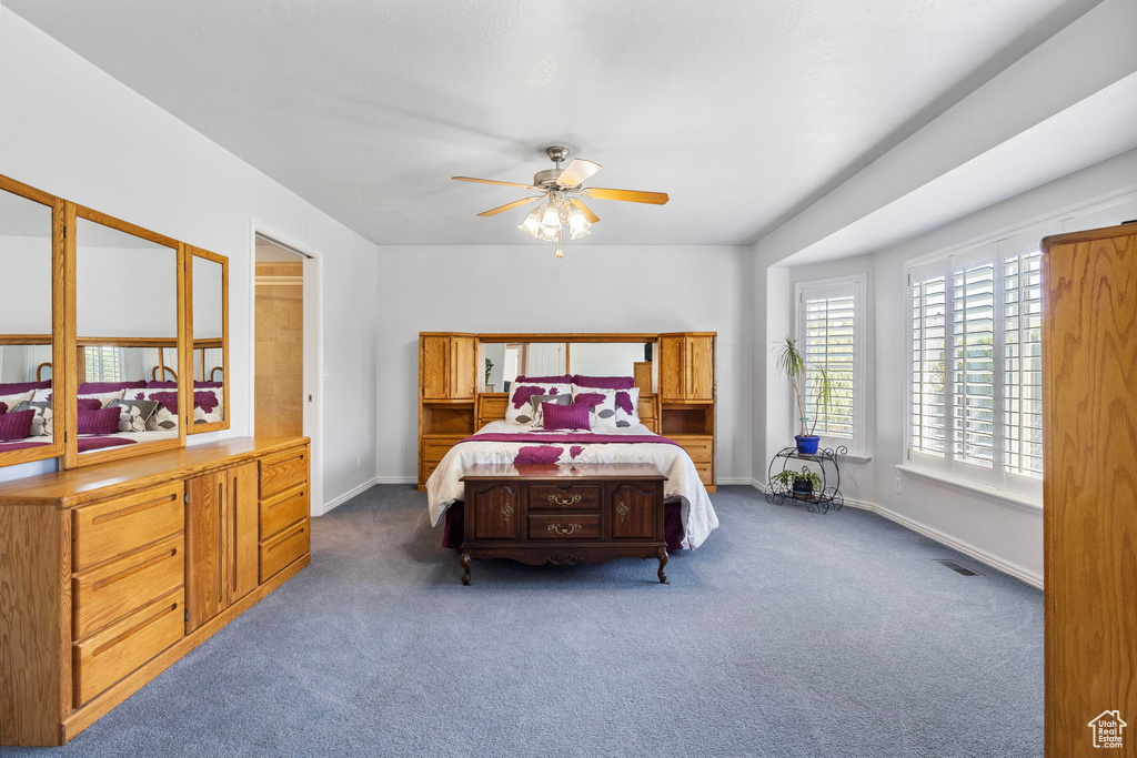 Bedroom with dark carpet and ceiling fan