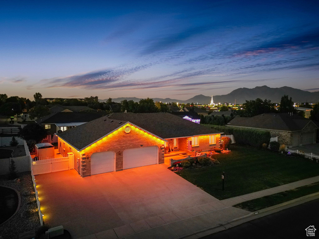 View of front facade featuring a mountain view, a garage, and a yard