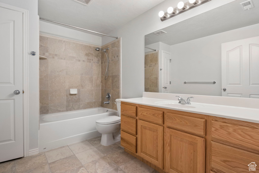 Full bathroom with vanity, toilet, and tiled shower / bath combo