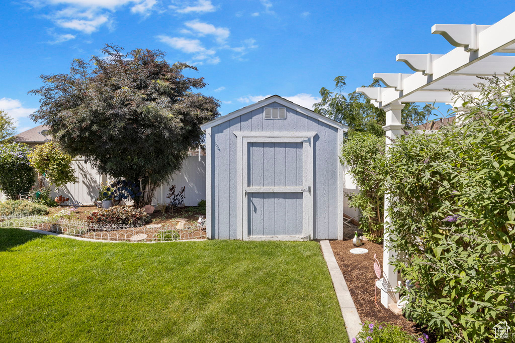 View of outbuilding featuring a lawn