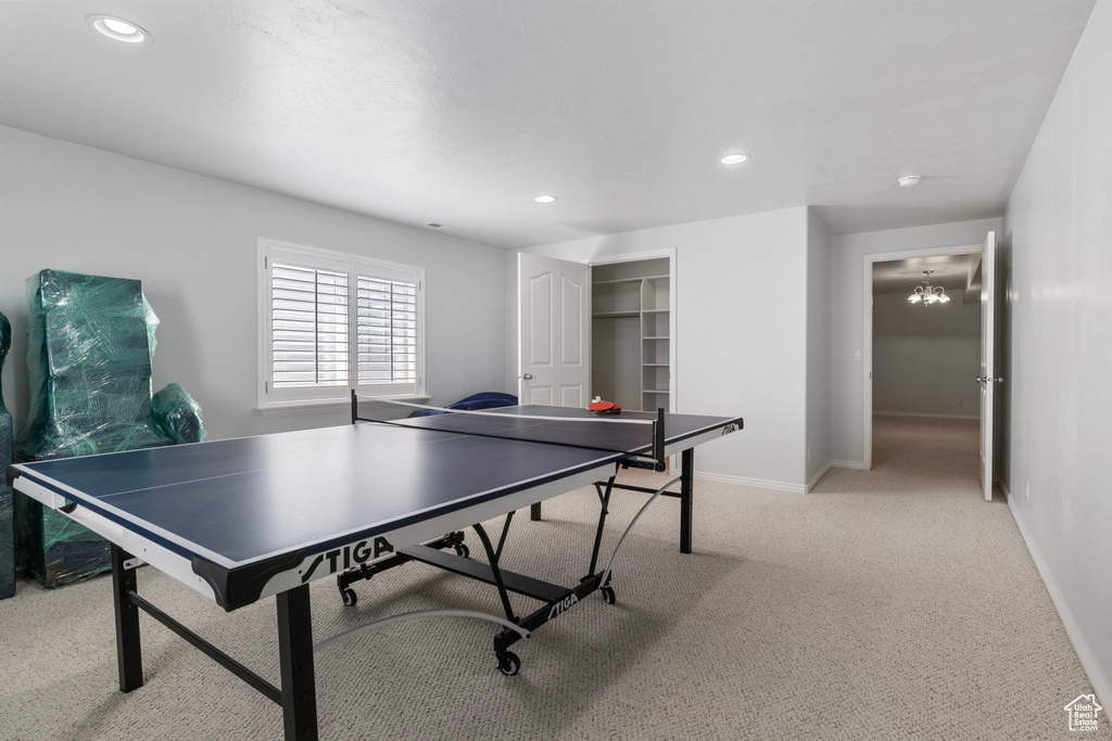 Recreation room featuring an inviting chandelier and light carpet