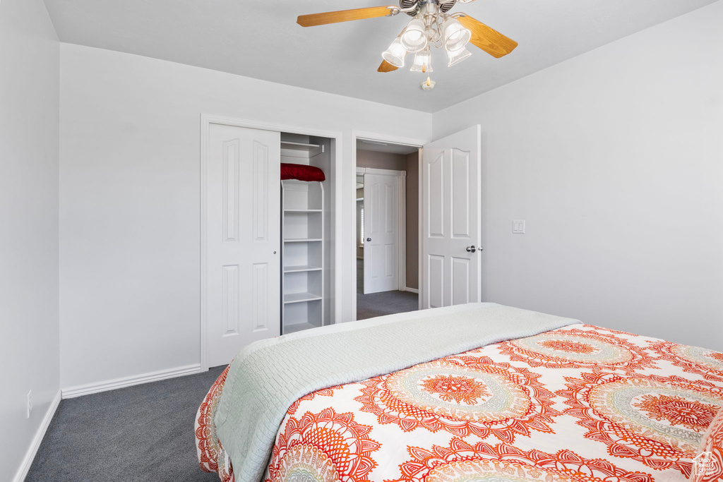 Carpeted bedroom featuring ceiling fan and a closet