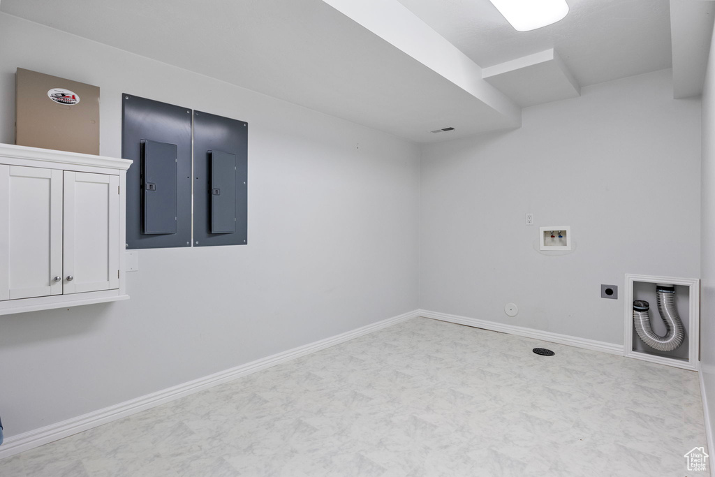 Clothes washing area featuring cabinets, hookup for a washing machine, gas dryer hookup, electric panel, and hookup for an electric dryer