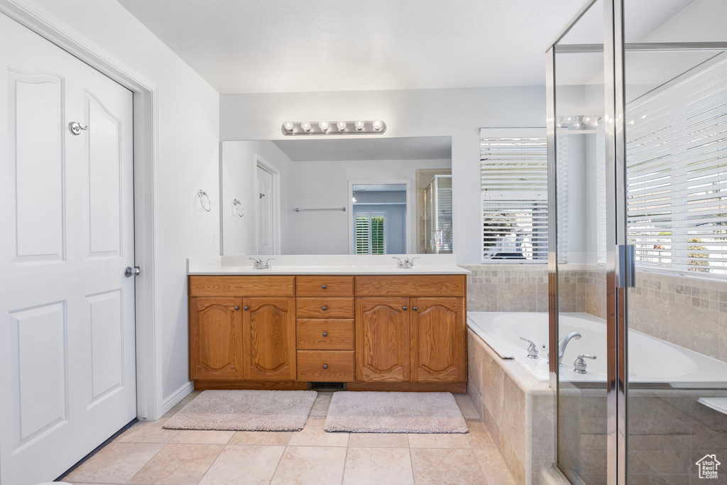 Bathroom featuring tile patterned flooring, vanity, and shower with separate bathtub