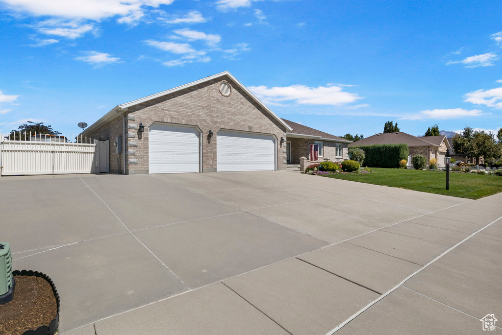 View of front of home with a garage and a front lawn