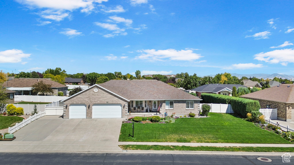 Ranch-style house featuring a front yard and a garage