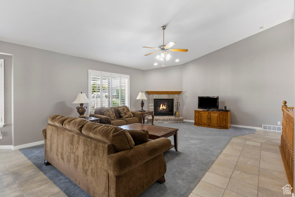 Living room with ceiling fan, a fireplace, and light carpet