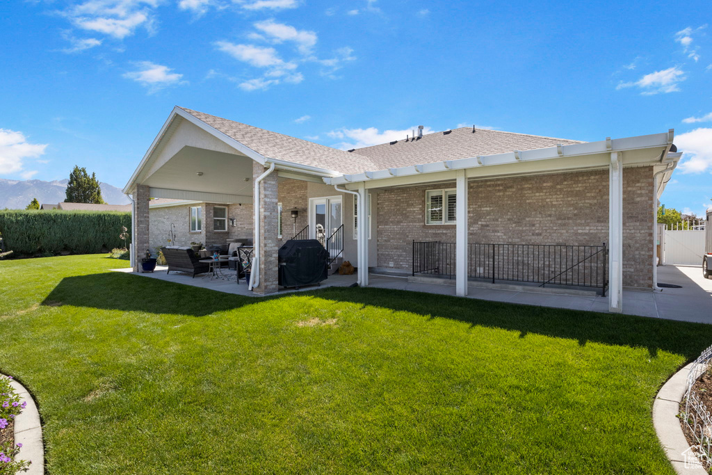 Back of property with a patio area and a yard