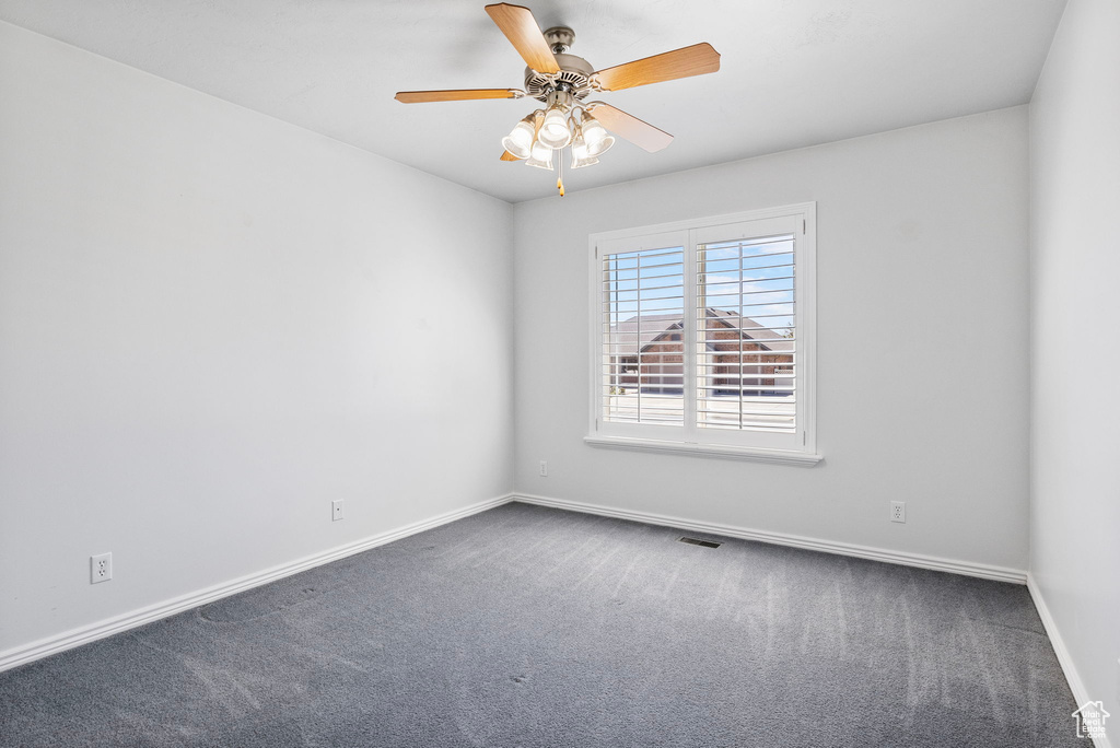 Carpeted spare room with ceiling fan