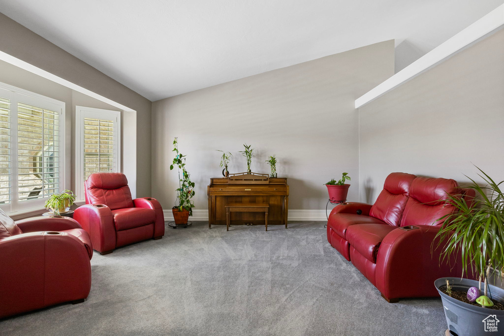 Carpeted living room with lofted ceiling