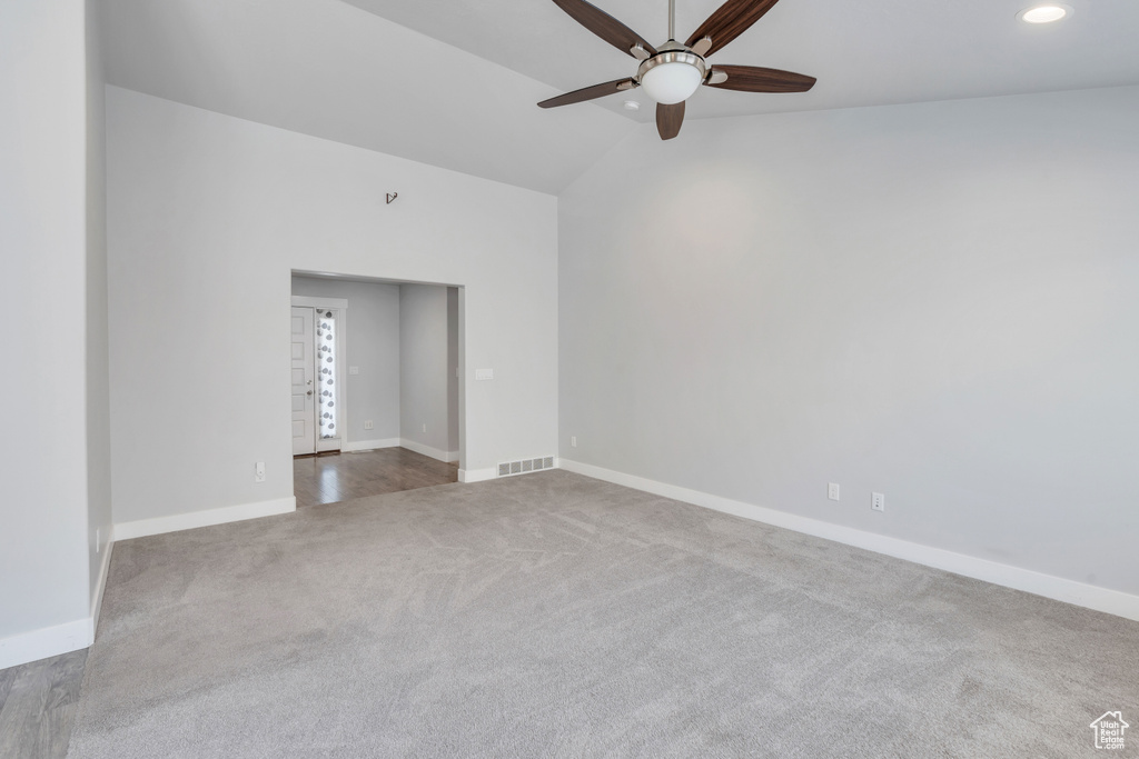 Unfurnished room featuring ceiling fan, vaulted ceiling, and wood-type flooring