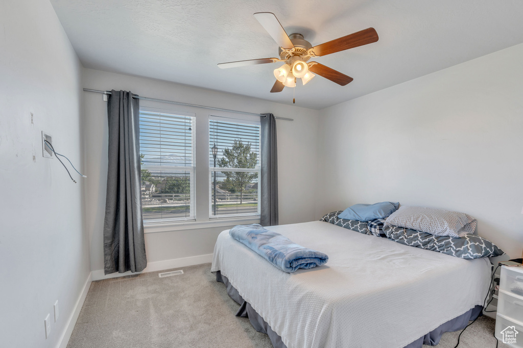 Carpeted bedroom featuring ceiling fan