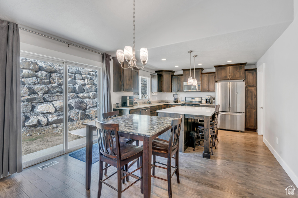 Dining space with sink, a notable chandelier, and hardwood / wood-style flooring