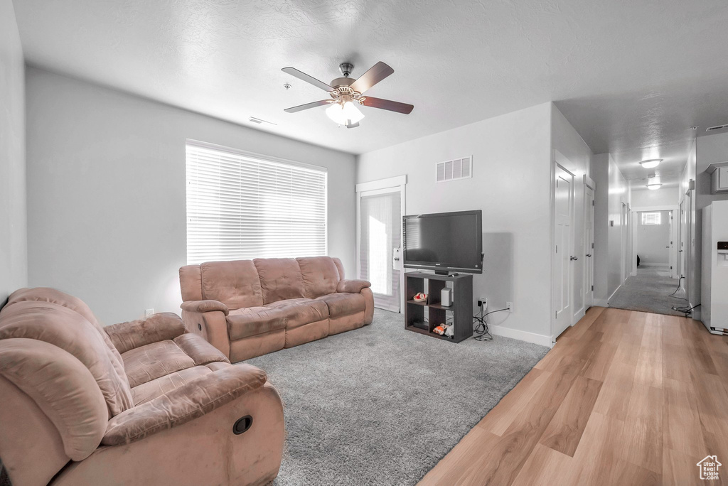 Living room with light wood-type flooring and ceiling fan