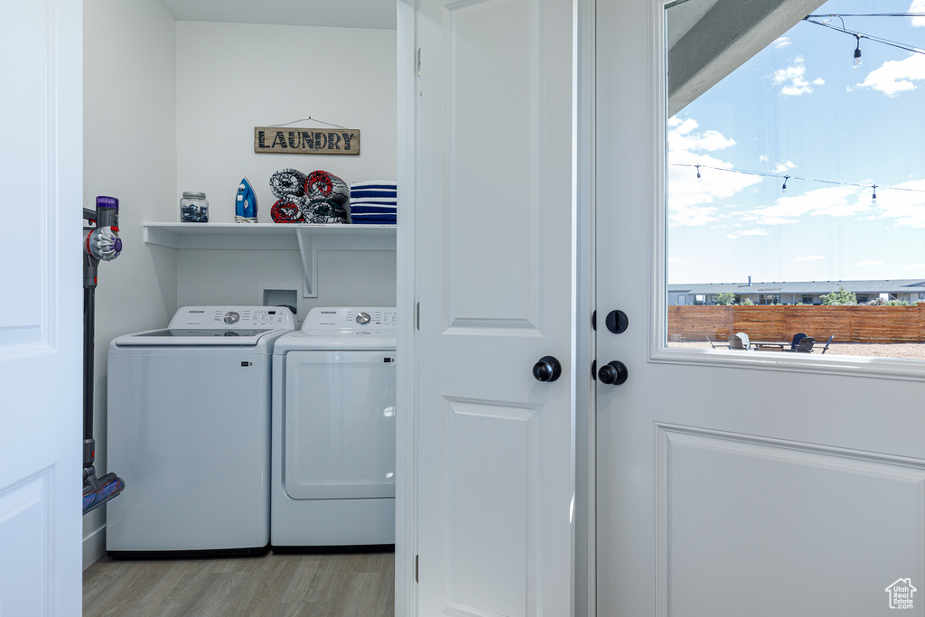 Clothes washing area featuring separate washer and dryer and light wood-type flooring