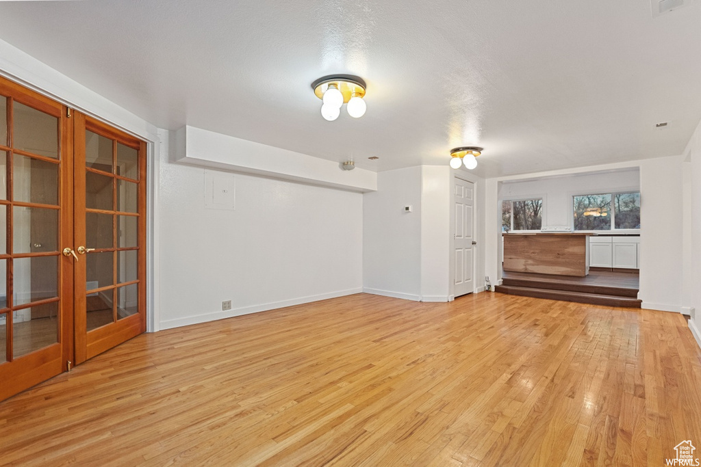 Unfurnished living room featuring a textured ceiling and light hardwood / wood-style flooring