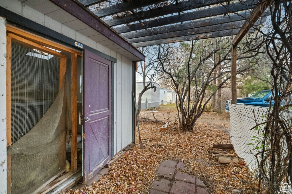 View of side of property featuring an outbuilding and a pergola