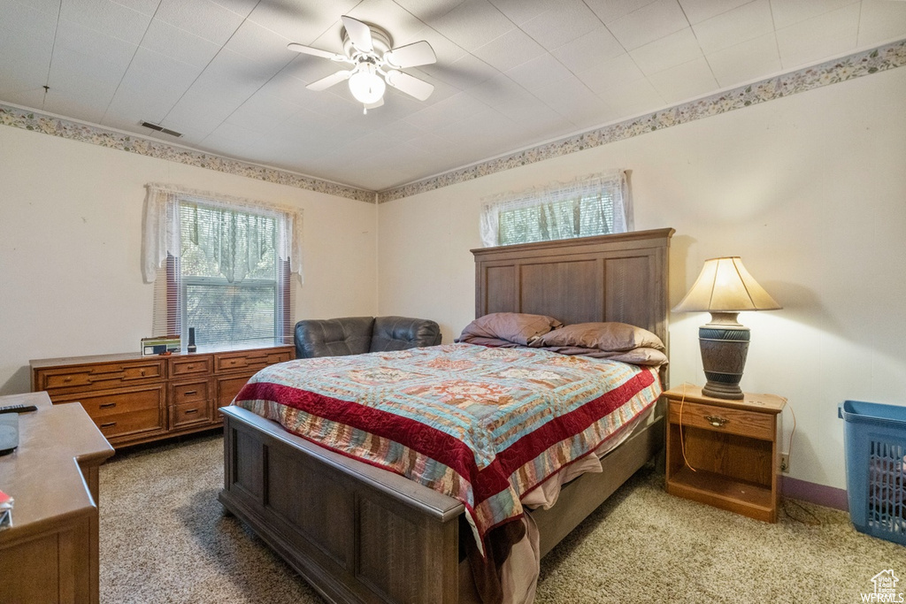 Carpeted bedroom featuring ceiling fan