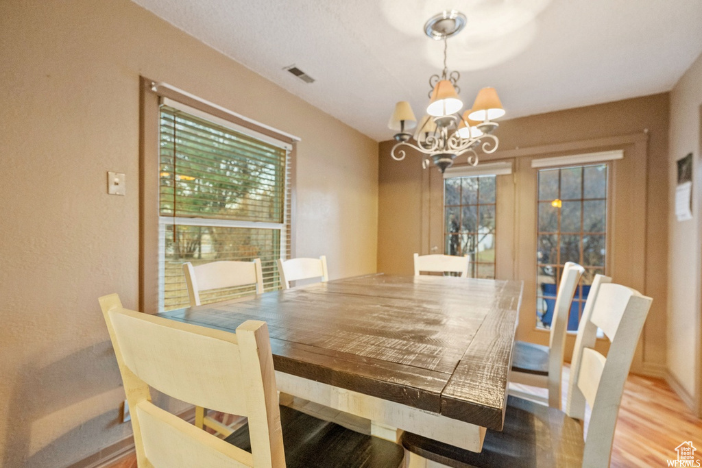 Dining room featuring hardwood / wood-style flooring and a notable chandelier