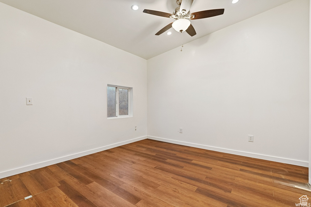 Spare room featuring lofted ceiling, ceiling fan, and wood-type flooring