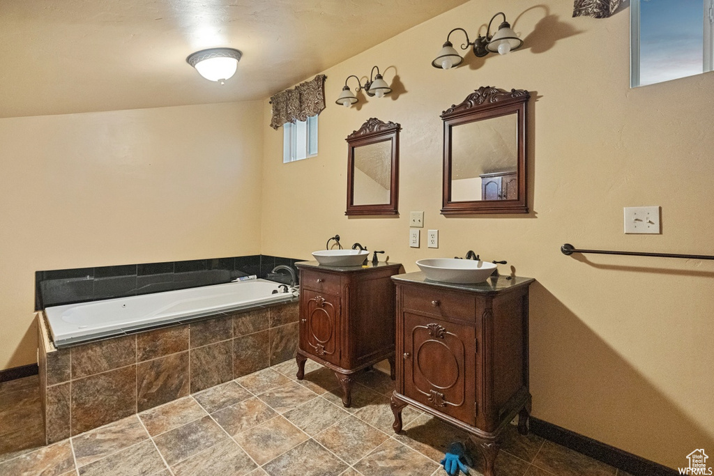 Bathroom featuring vanity and tiled tub