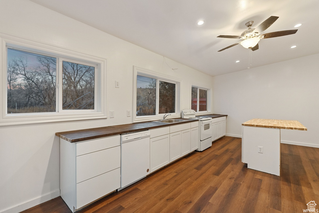 Kitchen featuring white appliances, butcher block countertops, dark hardwood / wood-style flooring, ceiling fan, and white cabinets