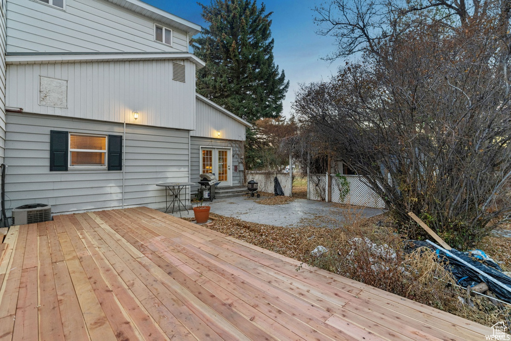 Deck featuring central air condition unit, grilling area, a patio, and french doors