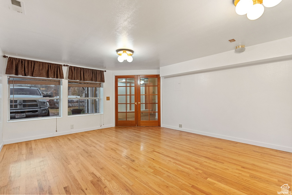 Unfurnished room with light wood-type flooring and french doors