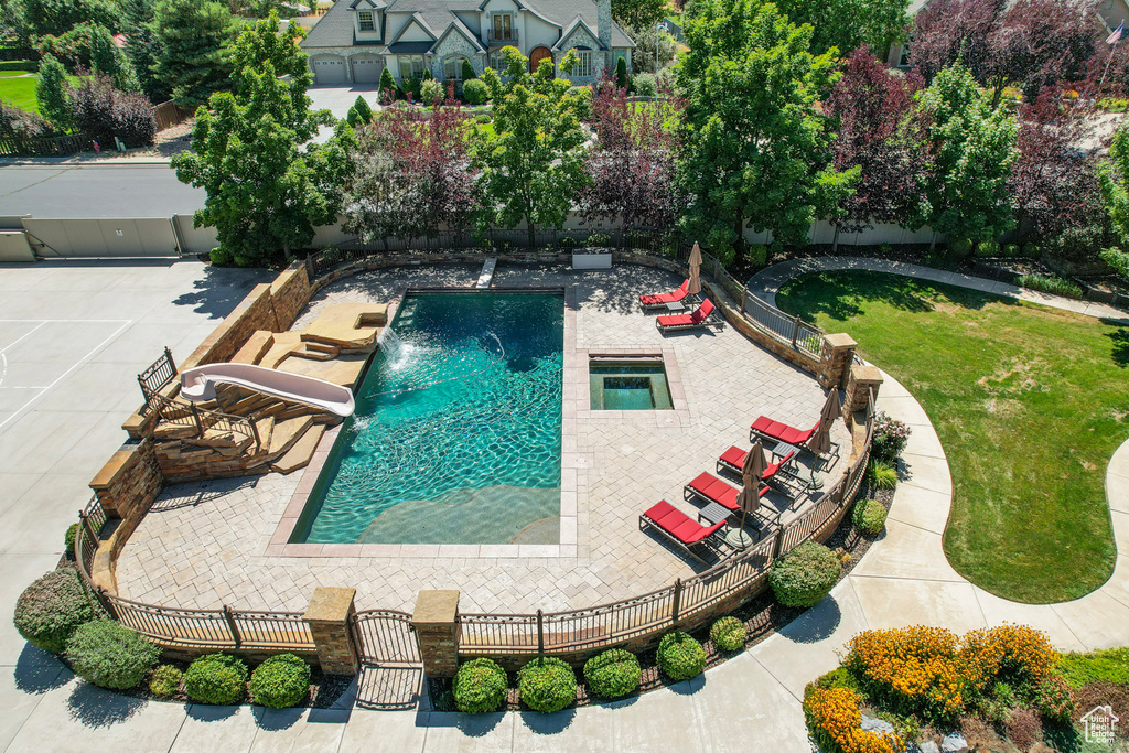 View of swimming pool with a water slide, pool water feature, a yard, and a patio area