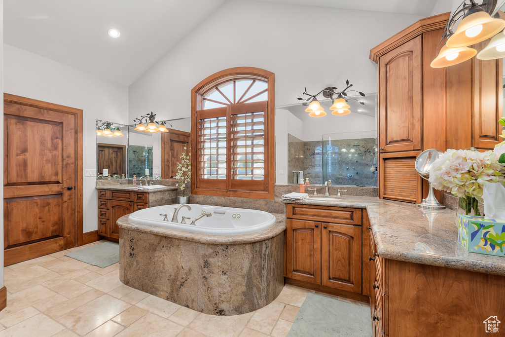 Bathroom with high vaulted ceiling, shower with separate bathtub, and vanity