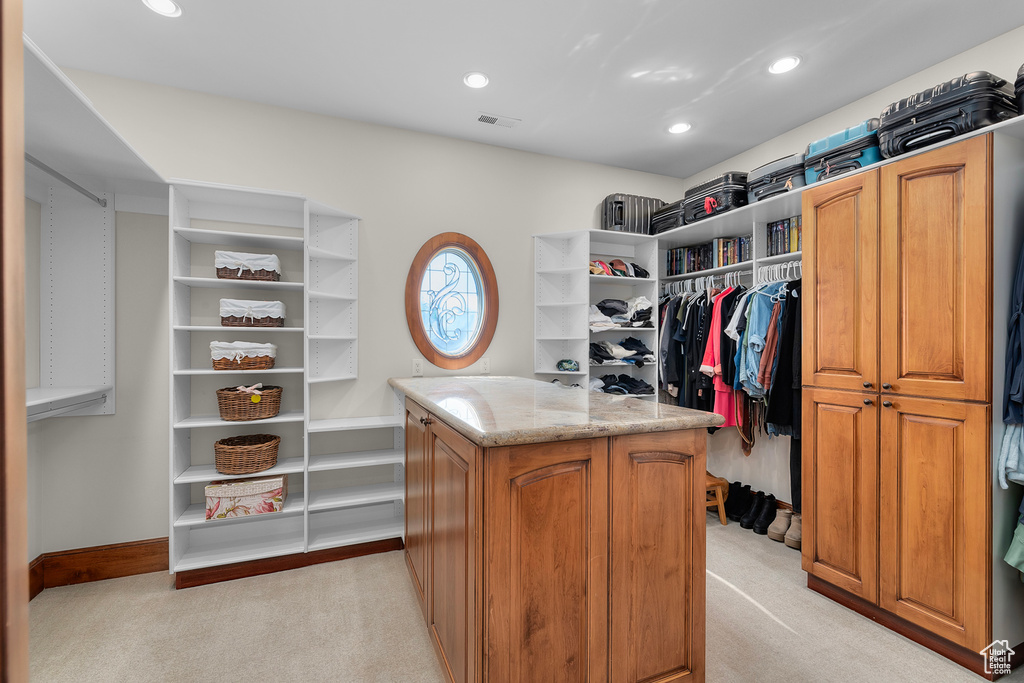 Spacious closet featuring light colored carpet