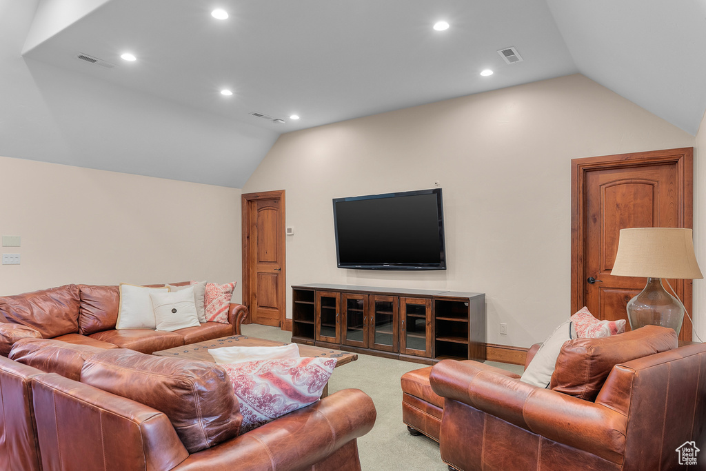 Carpeted living room featuring lofted ceiling