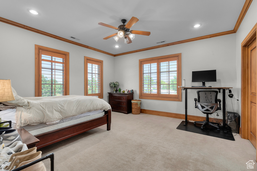 Carpeted bedroom with ceiling fan and ornamental molding