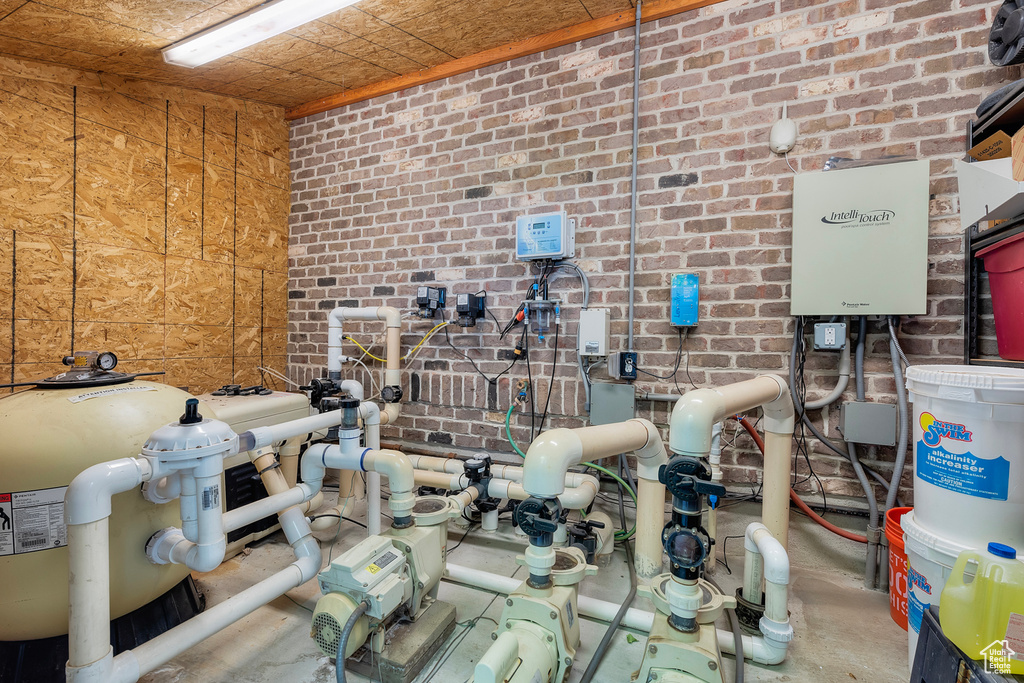 Miscellaneous room featuring concrete floors and brick wall